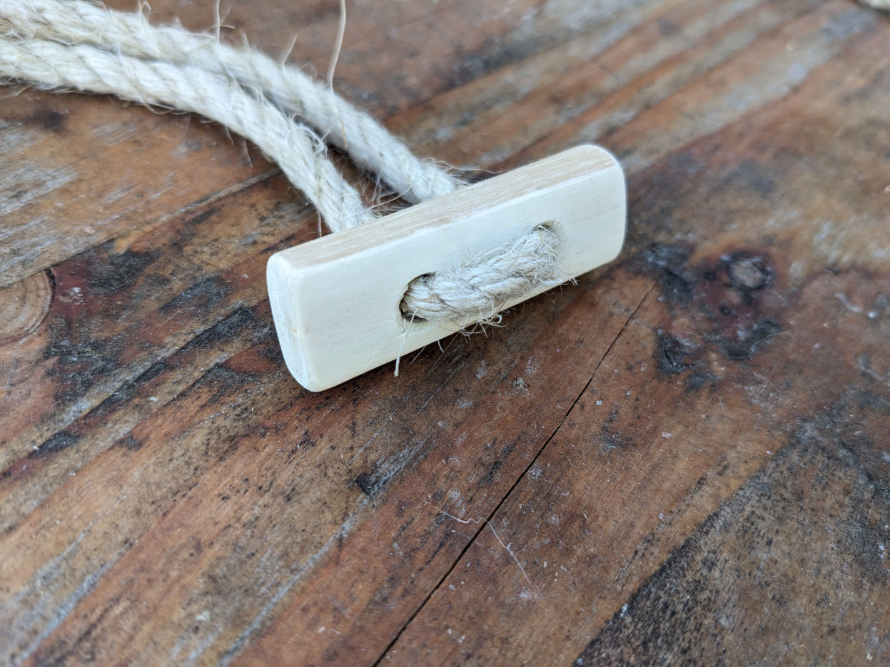 Handmade wooden toggles for securing the lids of our willow coffins