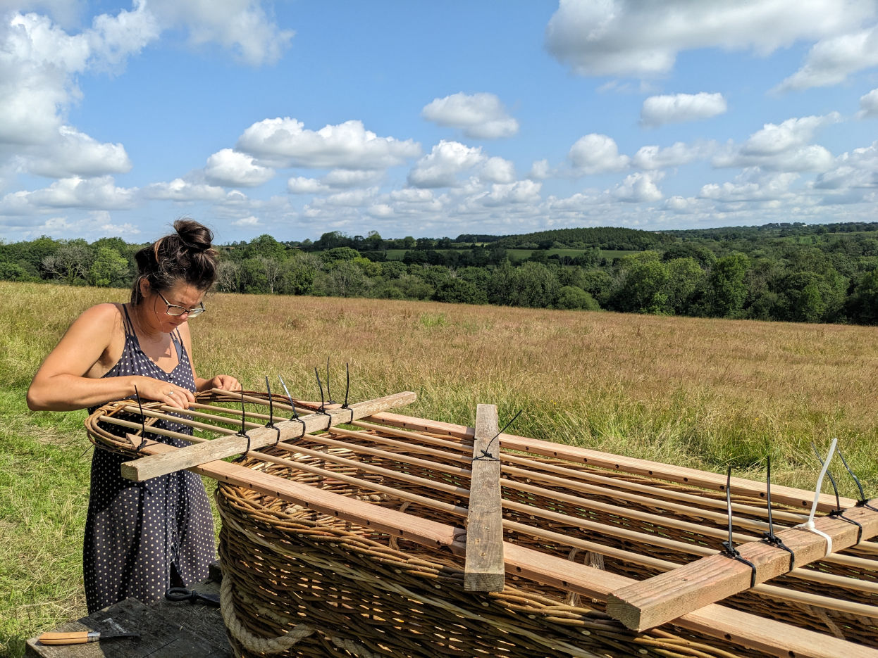 Willow coffin weaving in progress, showing the timber framework for the lid